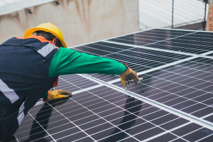 A solar technician installing a solar panel